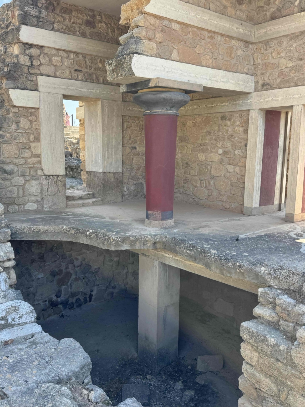 One of Knossos's famous reconstructed red columns, tapering downward in the traditional Minoan style — a feature unique to this civilization.