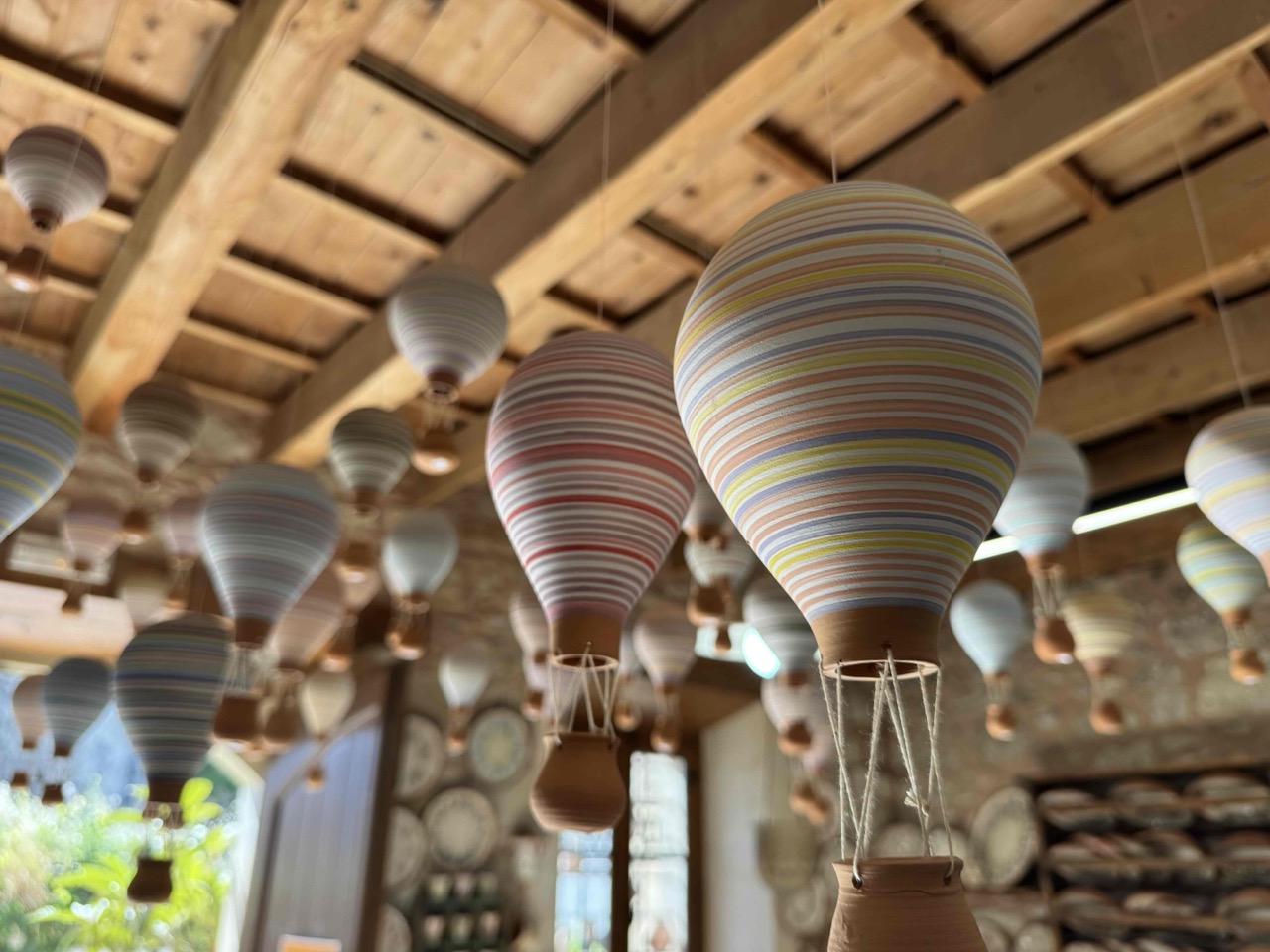 Beautiful pottery that the claymaker displayed across the ceiling of their shop. These balloons hold a clay basket that is designed to hold essential oils